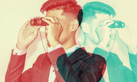 Two men facing in opposite directions using binoculars