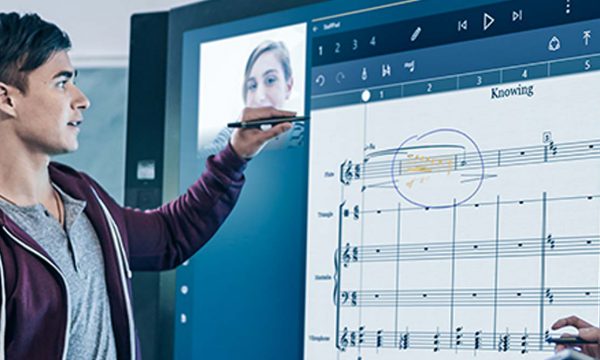 Student using Surface Hub in class with lecturer watching on