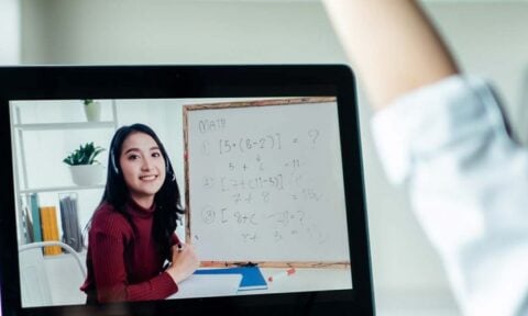 Young girl raising her hand in an online lesson