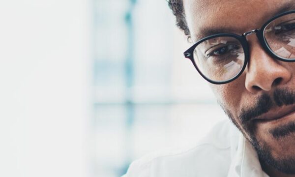 Man with glasses looking serious at computer