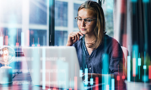 Young woman working at modern office.Technical price graph and indicator, red and green candlestick chart and stock trading computer screen background.