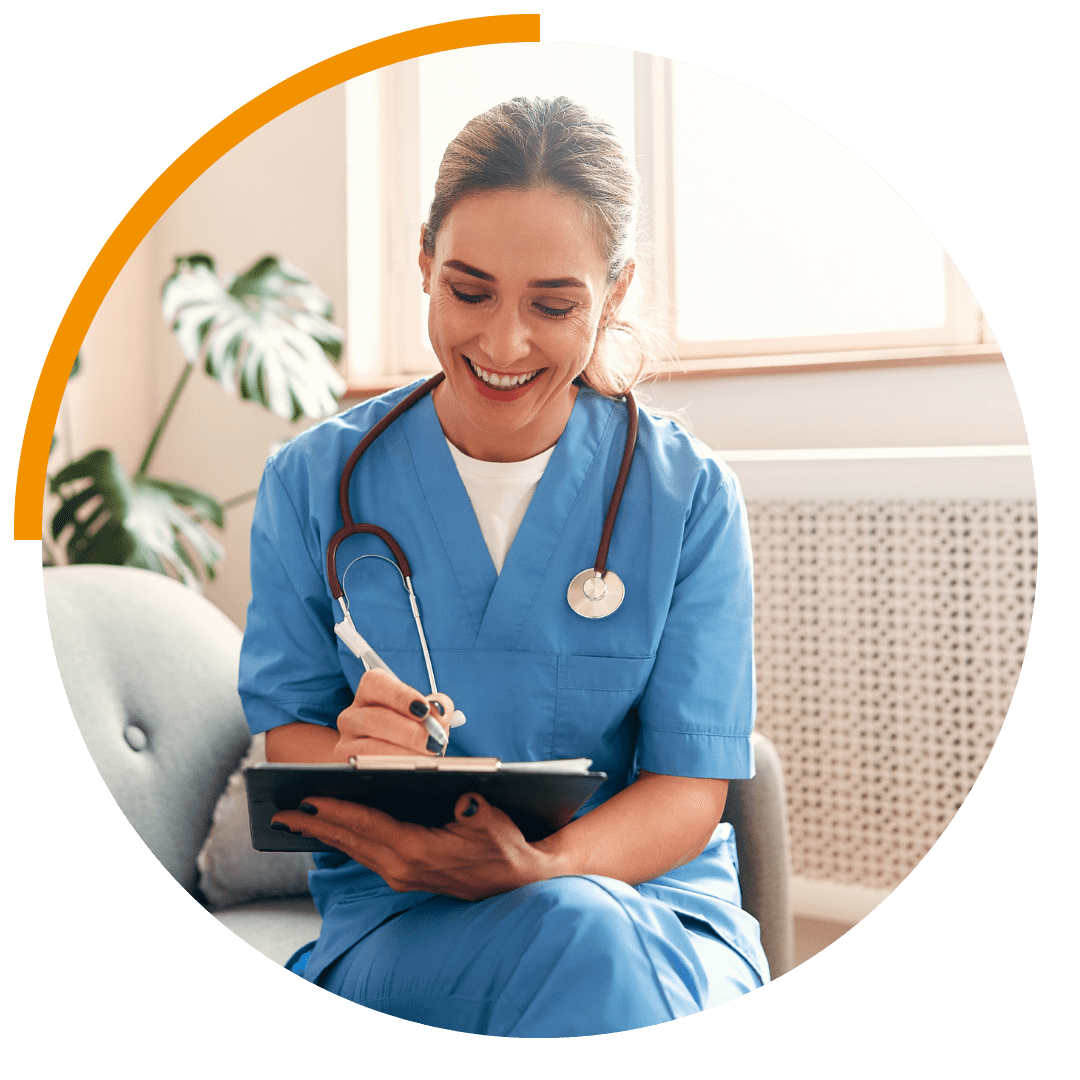 woman sat with ipad, wearing healthcare uniform