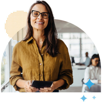 Person in an office holding a tablet device with other people working blurred in the background