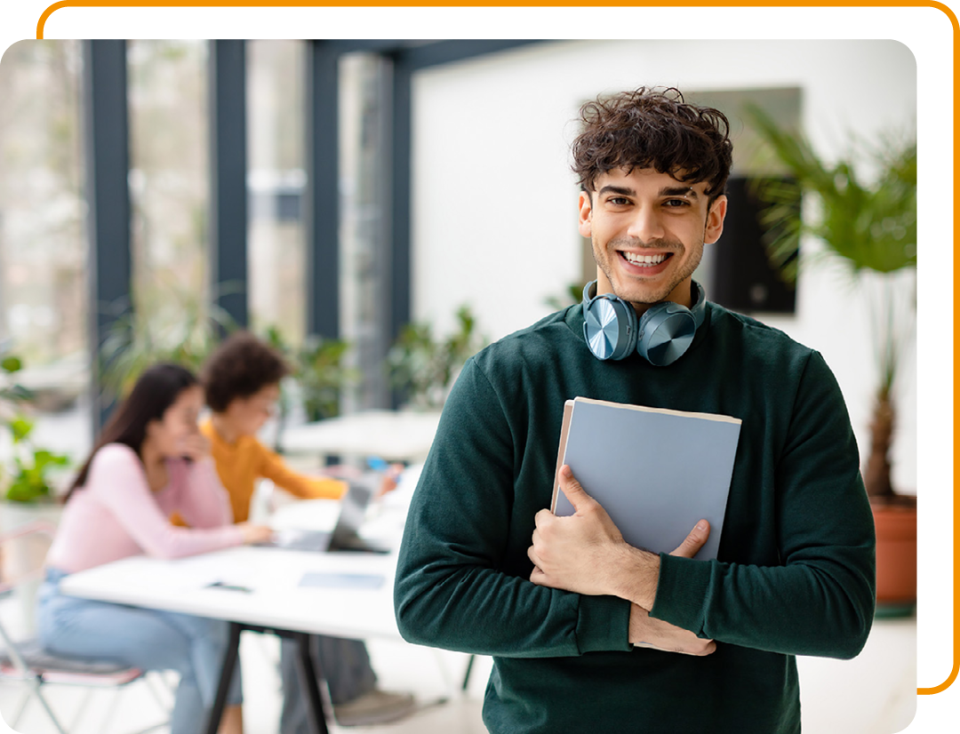 Image of a smiling person looking at the screen holding some books
