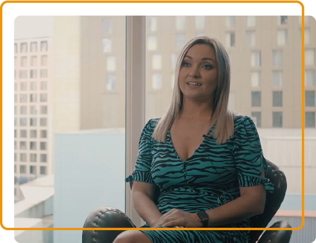Image of a person sat in an office space with buildings behind them