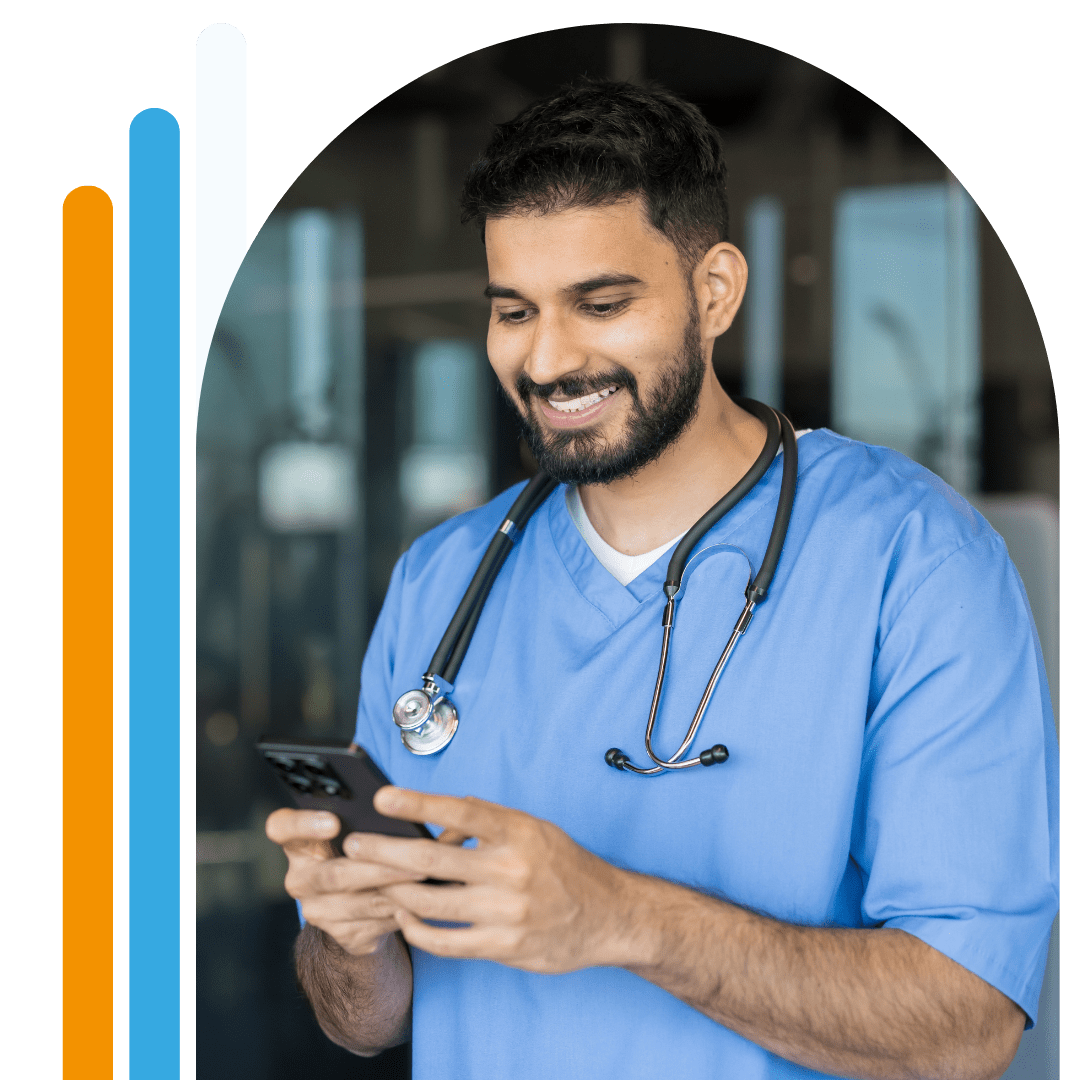 Man stood smiling in healthcare uniform using a phone