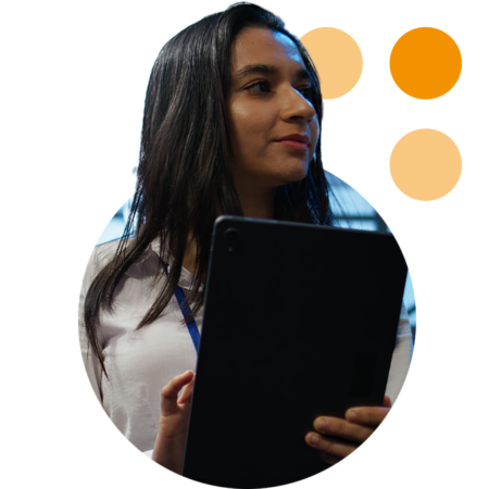 Image of an IT professional walking through a server room holding a tablet