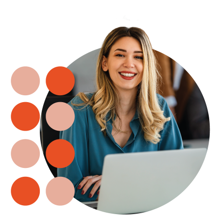 Portrait of business woman working on laptop smiling at camera sat at desk