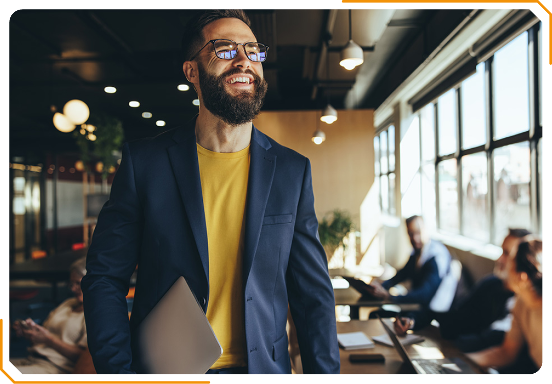 Image of a person holding a laptop walking through an office