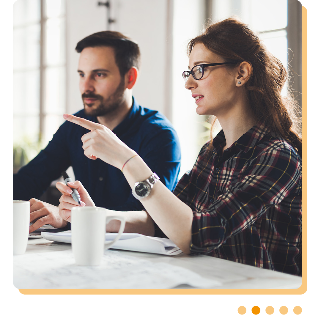 Image of two IT professionals conversing at a desk