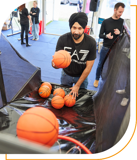 Image of a Phoenix employee using a basketball game at our 2024 Vendor Village