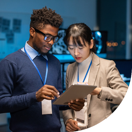 Image of two IT professionals looking at a tablet in an office