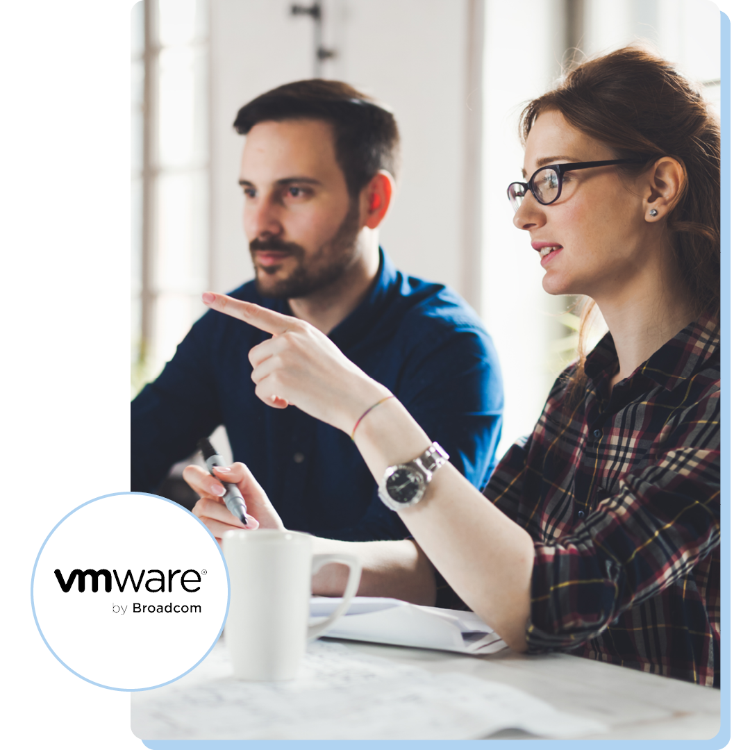 Image of two colleagues working together on a laptop with the VMware by Broadcom logo