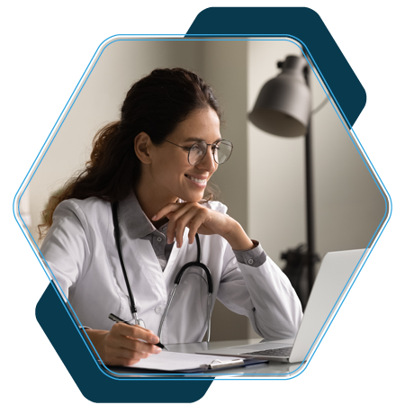Woman in healthcare uniform sat with laptop taking notes