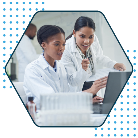 Two women in healthcare uniform looking at a laptop
