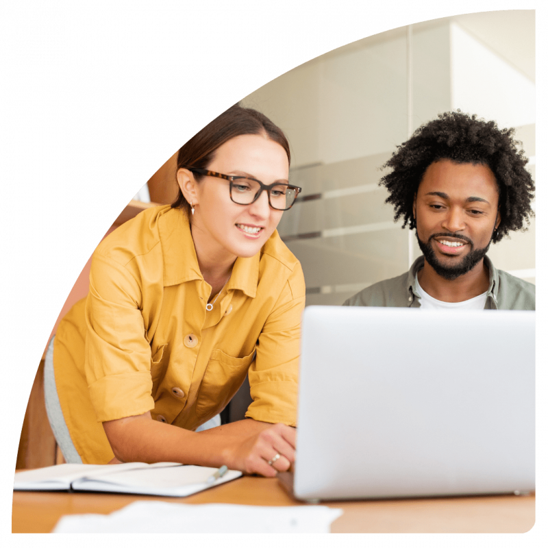 two friendly people smiling at laptop