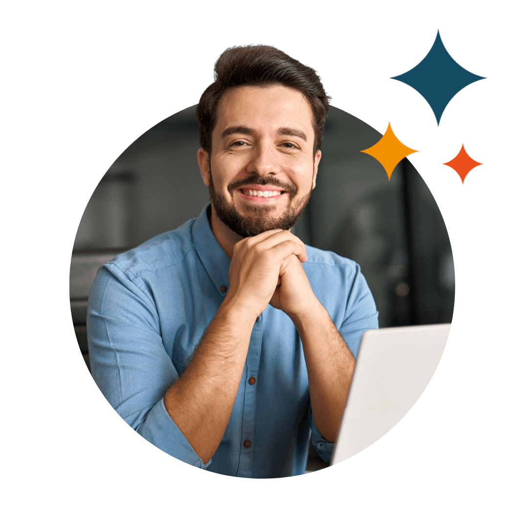 man sat smiling with laptop
