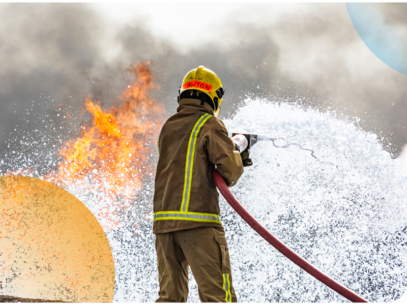 Image of a UK firefighter putting out a fire