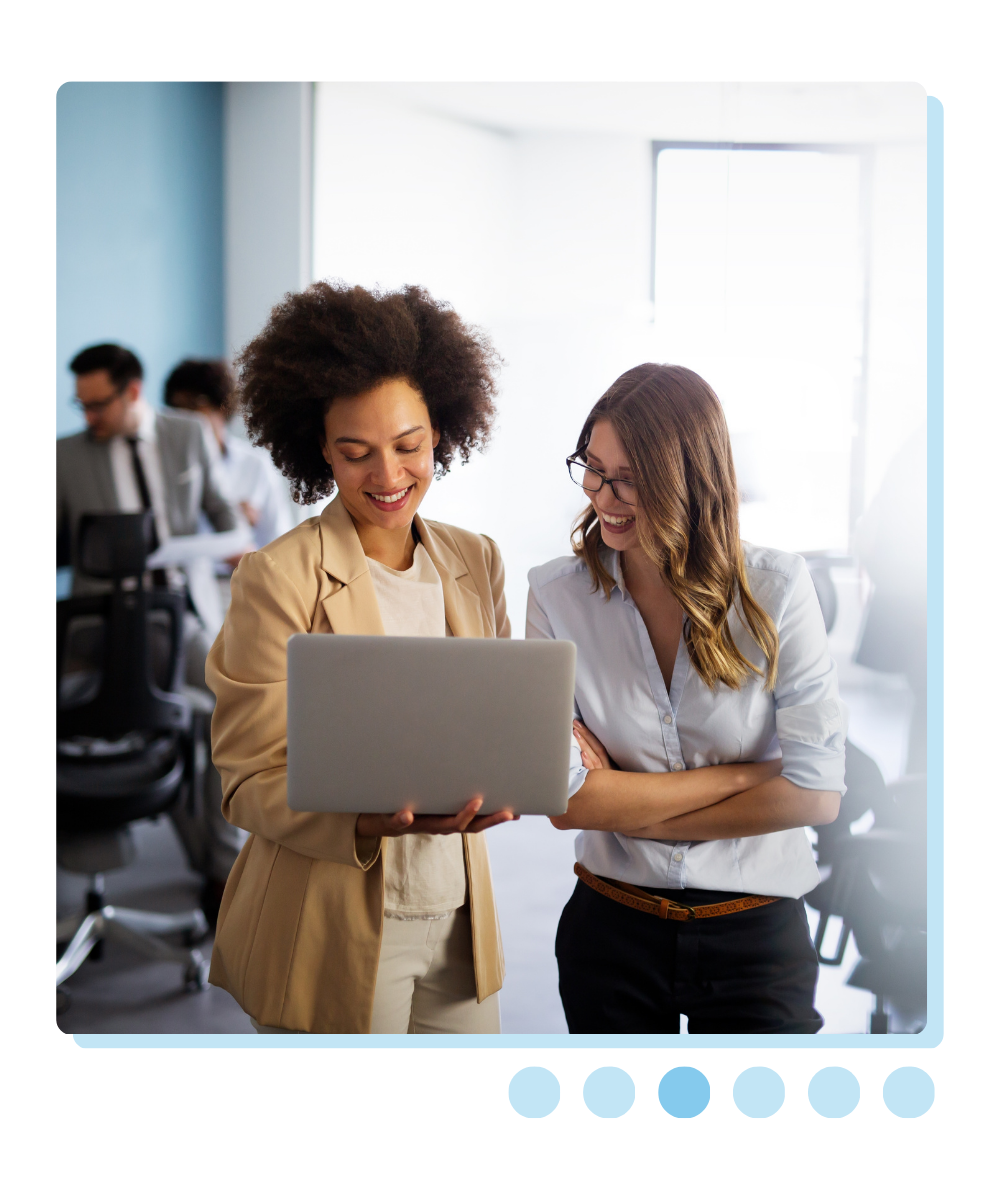 Two women smiling at laptop