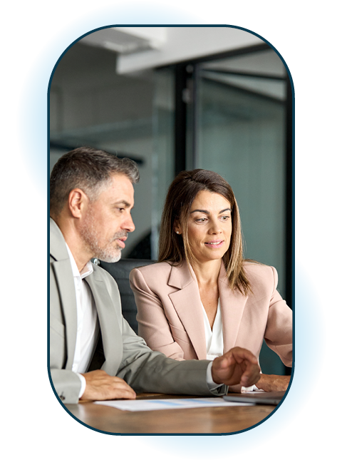 Two people sat at desk working on a laptop